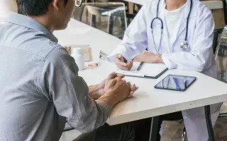 Profissional de jaleco branco em consulta com um cliente
